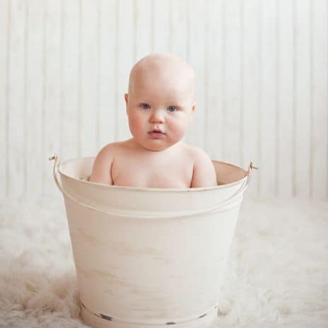 child in tub waiting for bath toys