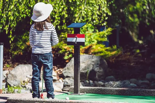 child playing mini golf