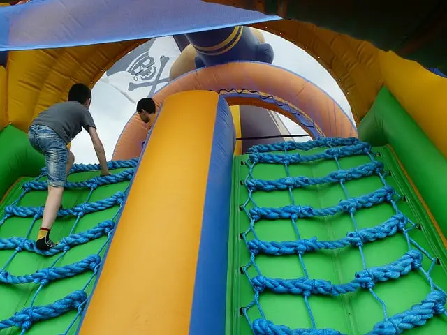 children playing on inflatable obstacle course